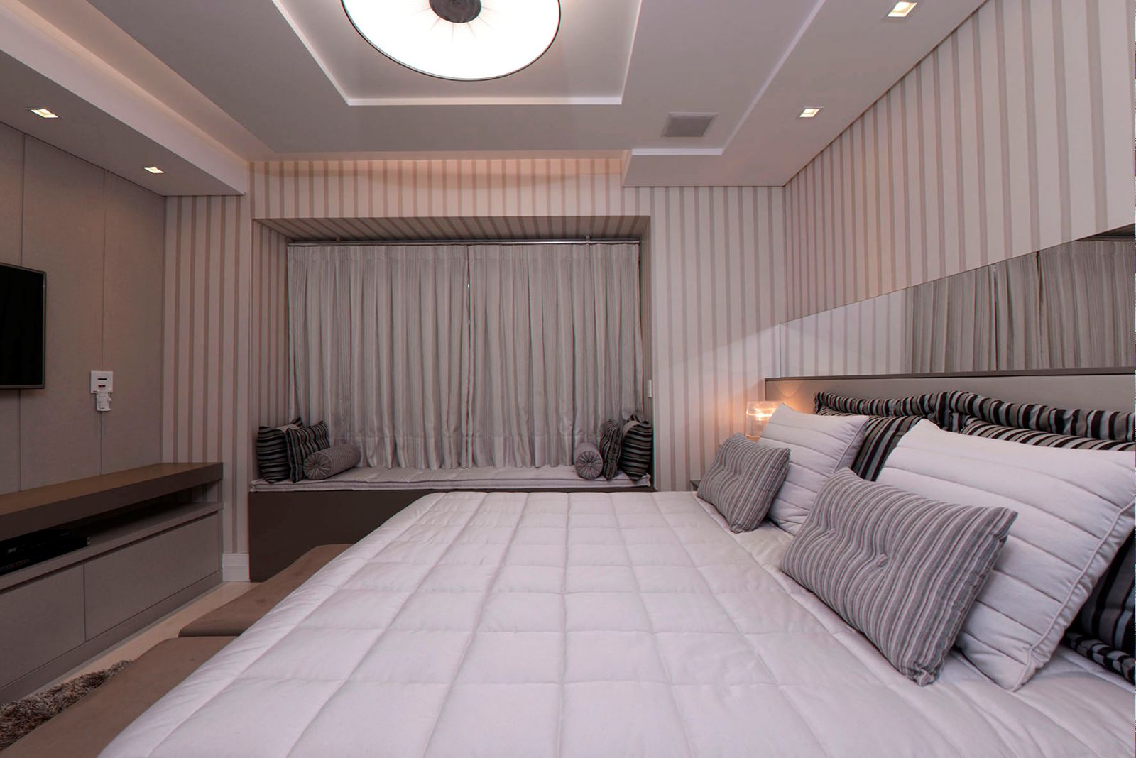 Quarto com cortina de voil e papel de parede listrado